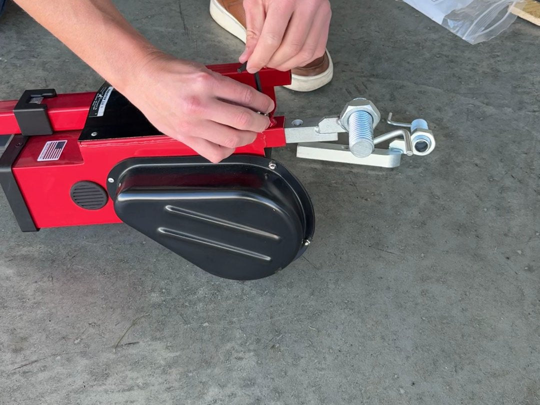 Fitting an adapter into the forks of a Robotow 2.0 on a hangar floor.