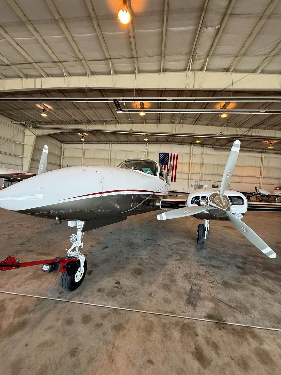 A Cessna 310RG in the hangar with a Robotow 2.0 Pro on its nose gear.