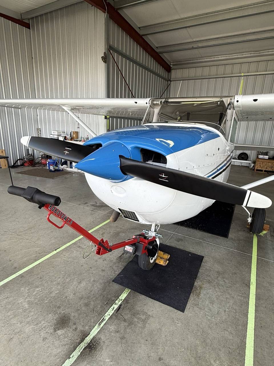 A Robotow Pro on the nose wheel of a Cessna 172K in a hangar.