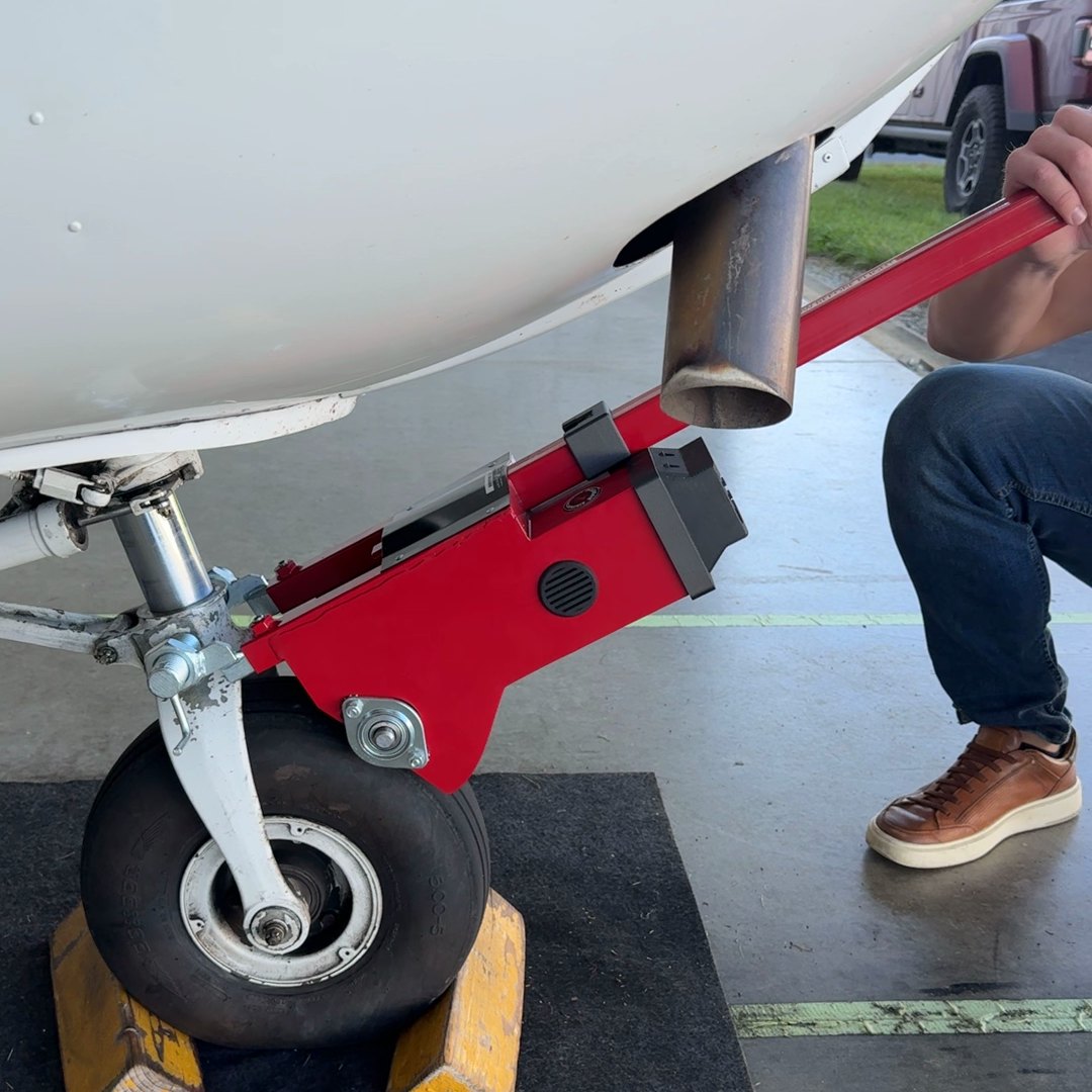 Hooking a Robotow 2.0 to a Cessna 172 nose wheel: adapter on the nose gear, drum on the tire.
