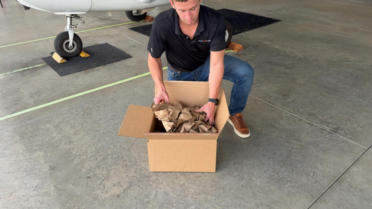 Unpacking a Robotow 2.0 kit from its shipping box in a hangar.